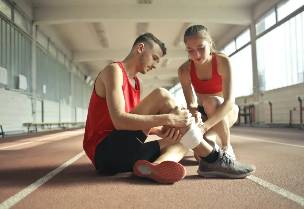 A runner holding his leg on a track.