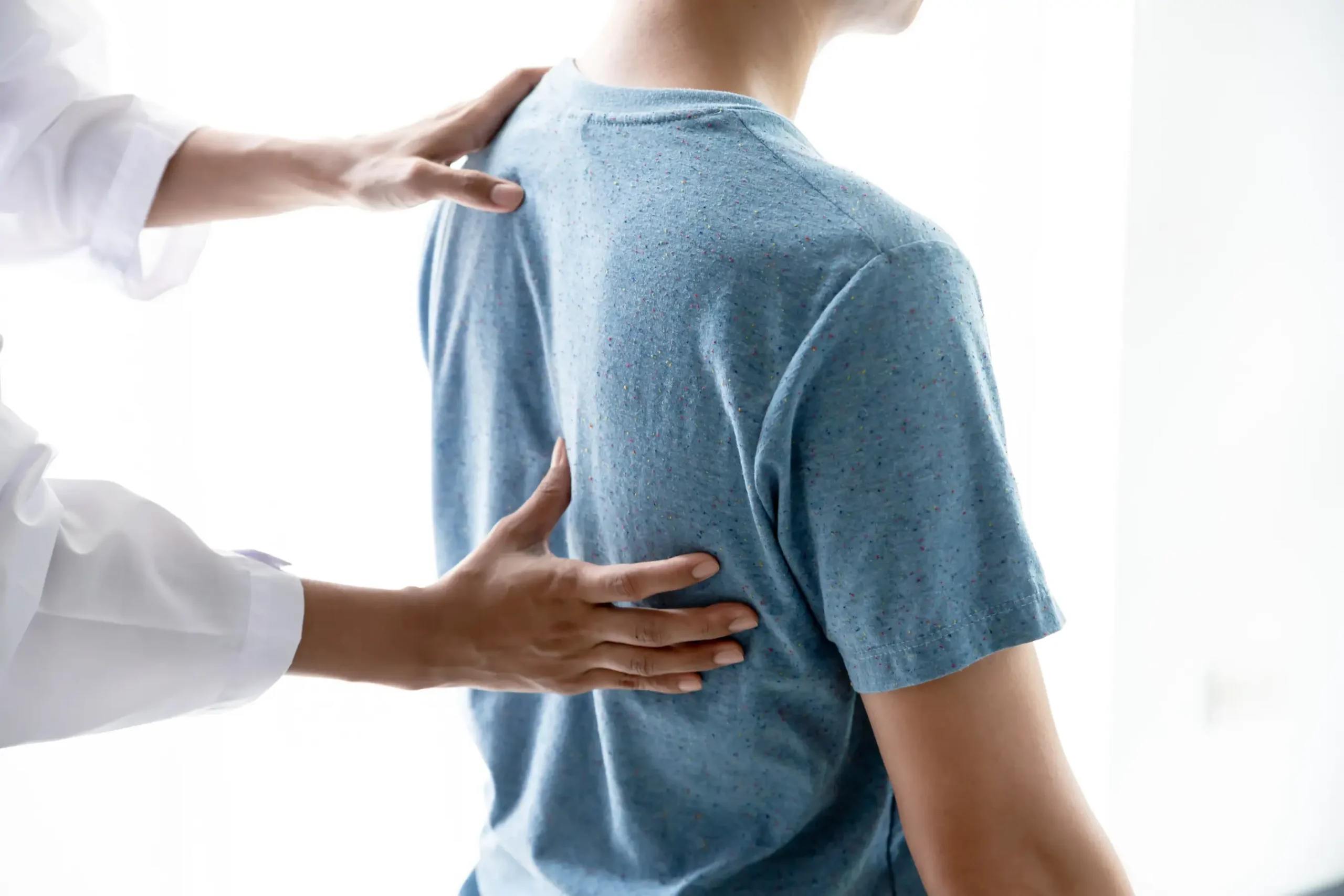 A doctor examining a patient's back.