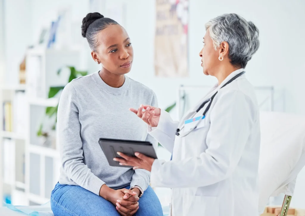 A patient meeting with a doctor in a medical setting.