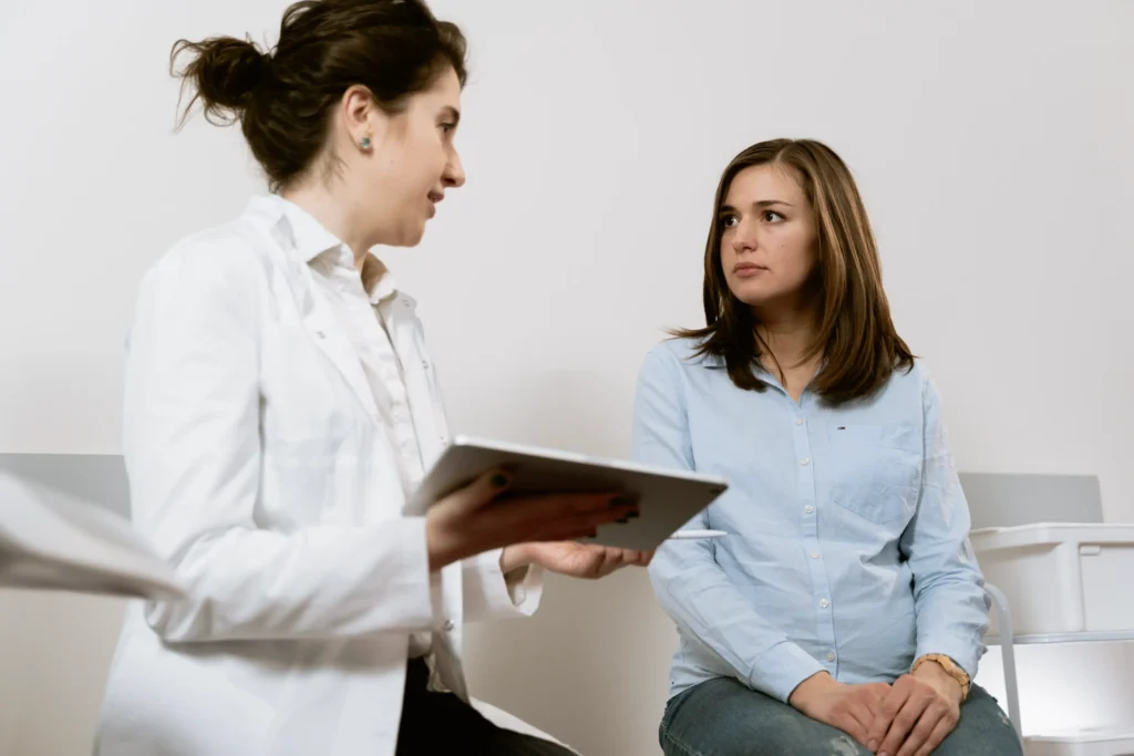 Female doctor holding a tablet and discussing treatment options with a patient, representing comparison with other pain management treatments.